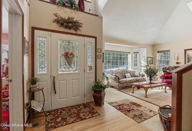 entrance foyer featuring high vaulted ceiling and wood finished floors