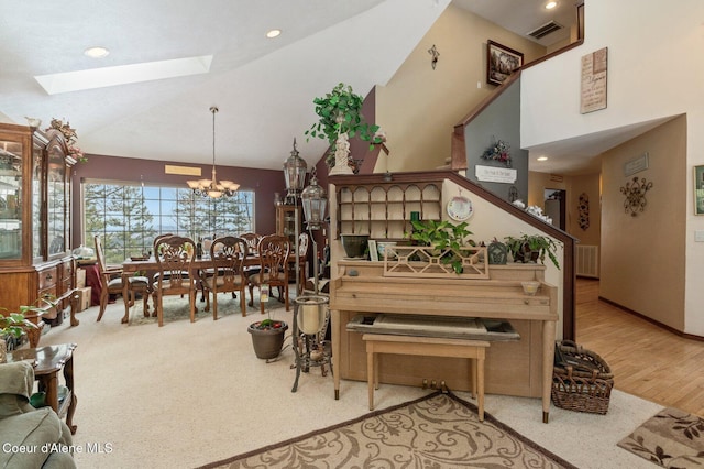 dining space with high vaulted ceiling, a skylight, visible vents, and a notable chandelier