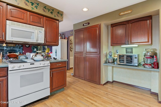 kitchen featuring recessed lighting, a toaster, white appliances, baseboards, and light wood finished floors