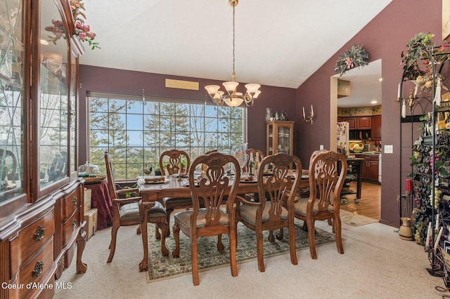 dining room with lofted ceiling, light carpet, and a chandelier