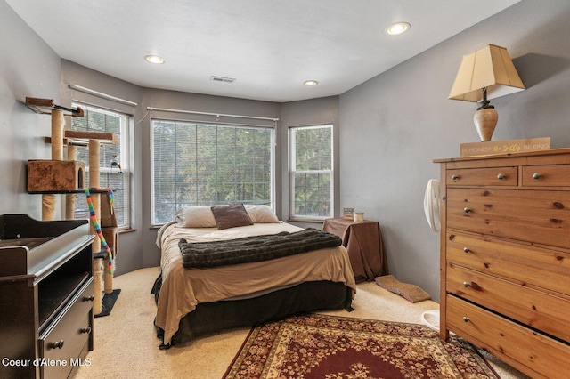 bedroom with light carpet, visible vents, and recessed lighting