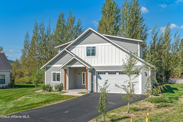 view of front of house featuring a front yard, driveway, board and batten siding, and an attached garage