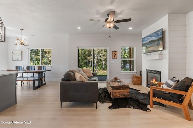 living room with a wealth of natural light, a fireplace, recessed lighting, and wood finished floors