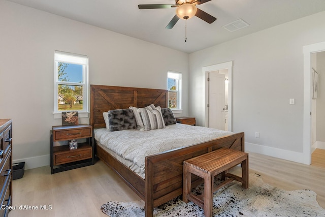 bedroom with visible vents, baseboards, light wood finished floors, and a ceiling fan