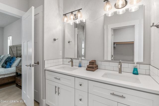 full bath featuring double vanity, a sink, and decorative backsplash