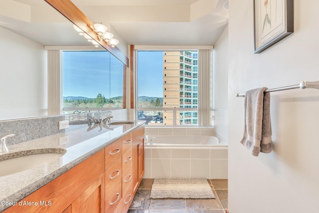 full bath featuring double vanity, tiled tub, and a sink