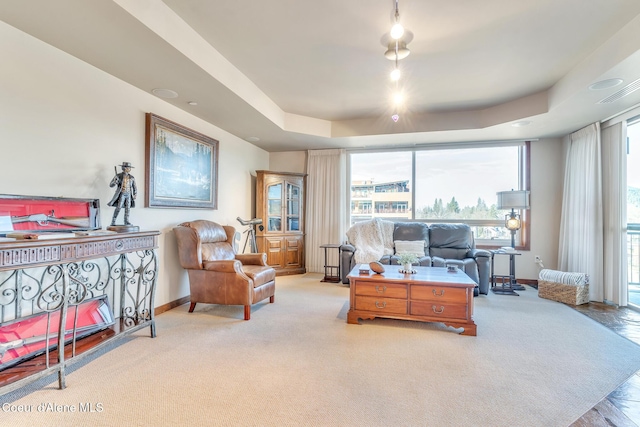 interior space with carpet, visible vents, baseboards, and a raised ceiling