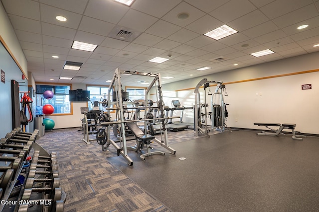 exercise room featuring a drop ceiling, visible vents, and baseboards