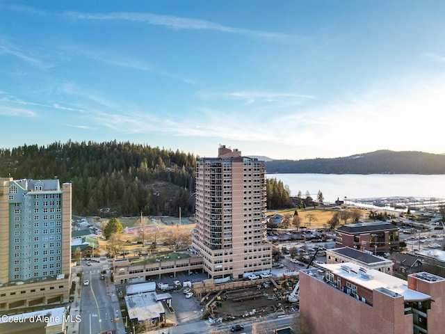 birds eye view of property with a water view, a wooded view, and a city view