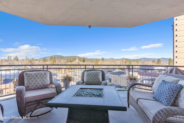 balcony featuring an outdoor living space with a fire pit and a mountain view