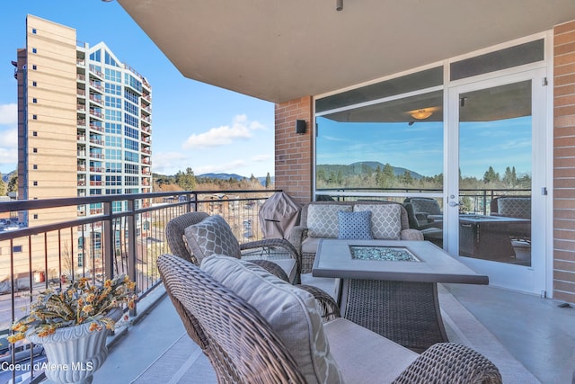 balcony featuring an outdoor living space with a fire pit and a mountain view