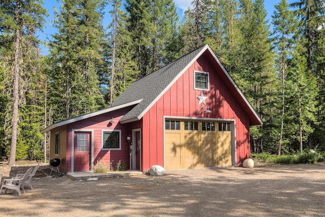 garage with a detached garage and a wooded view