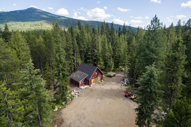 aerial view featuring a wooded view and a mountain view