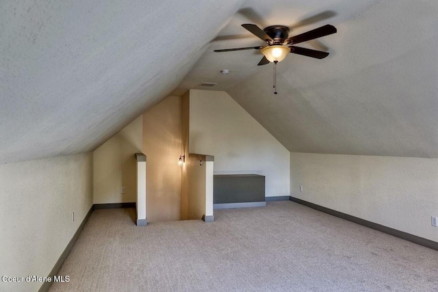 additional living space featuring lofted ceiling, carpet flooring, a textured ceiling, and baseboards