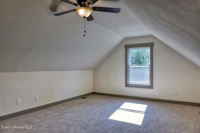 bonus room with a textured ceiling, baseboards, carpet flooring, and lofted ceiling