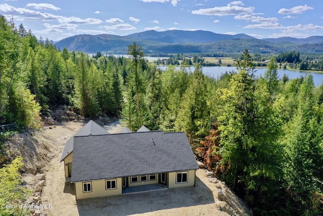 drone / aerial view with a wooded view and a water and mountain view