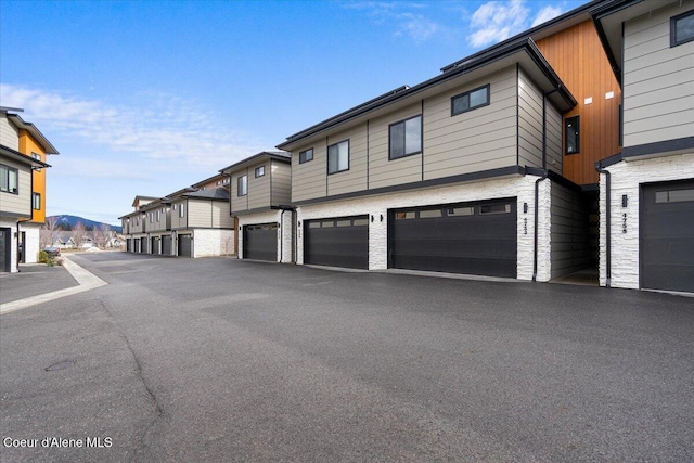 exterior space featuring a garage and stone siding