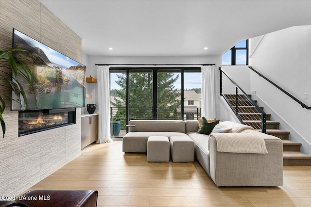 living room with a healthy amount of sunlight, a fireplace, and light wood finished floors