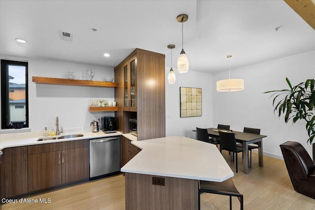 kitchen featuring dishwasher, a breakfast bar, light wood-style floors, open shelves, and a sink