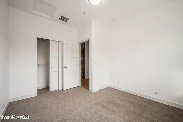 unfurnished bedroom with carpet, a closet, visible vents, and baseboards