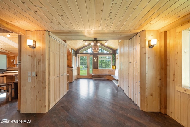 corridor with dark wood-style floors, wooden ceiling, wood walls, and vaulted ceiling with beams