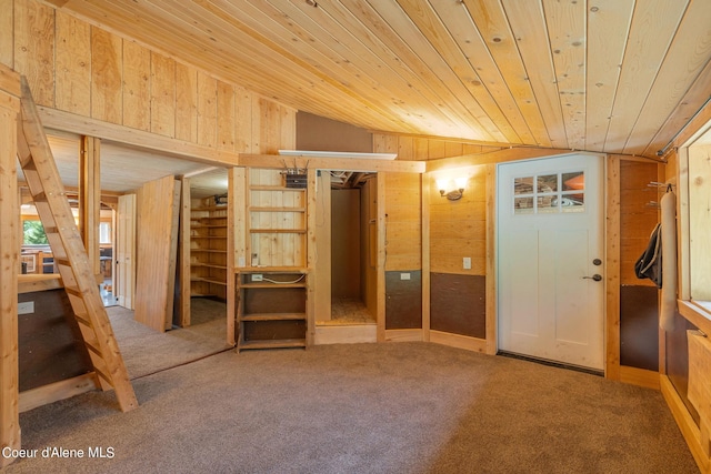 interior space featuring lofted ceiling, wooden ceiling, and wooden walls