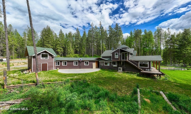 back of house featuring a patio, a wooden deck, and a lawn