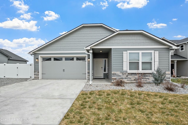 view of front of property with a garage, fence, concrete driveway, stone siding, and a gate