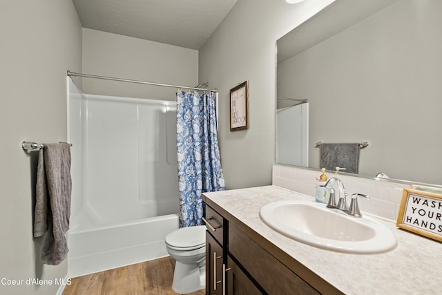 full bath featuring toilet, wood finished floors, vanity, decorative backsplash, and shower / bathtub combination with curtain