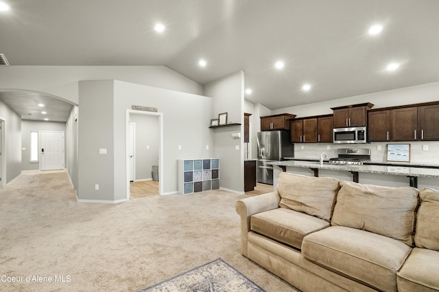 living room with visible vents, arched walkways, light colored carpet, lofted ceiling, and recessed lighting