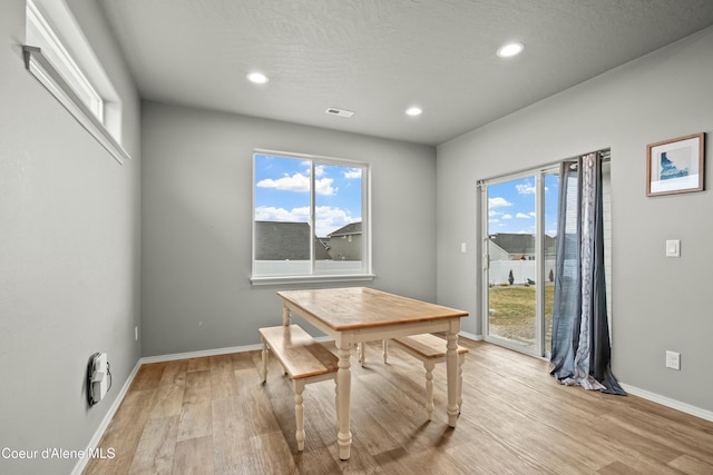 dining space with a textured ceiling, recessed lighting, visible vents, baseboards, and light wood finished floors