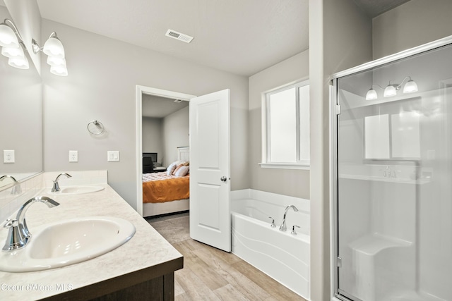 ensuite bathroom with connected bathroom, visible vents, a sink, and a shower stall