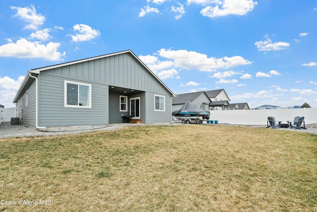 rear view of property featuring a patio, central AC unit, a lawn, and fence