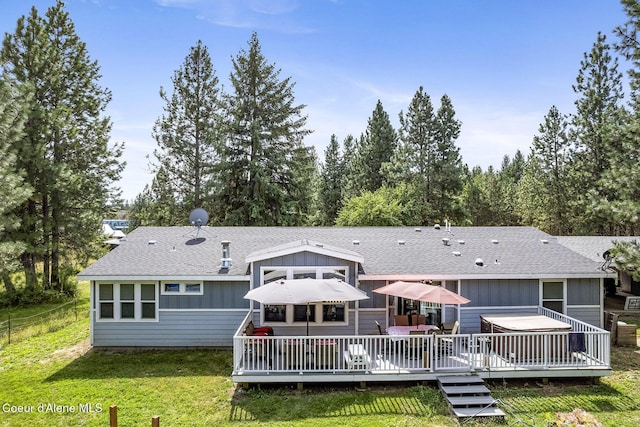 11248 N Bruss Rd, Rathdrum, ID 83858 - back of house with a shingled roof, fence, a deck, and a lawn