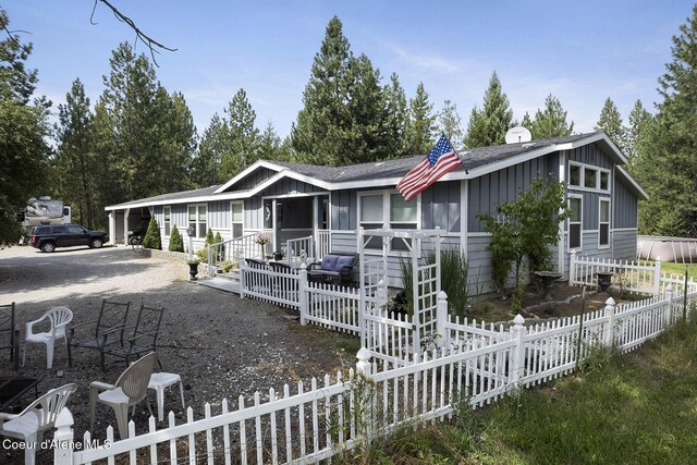 11248 N Bruss Rd, Rathdrum, ID 83858 - view of front facade with board and batten siding, roof with shingles, and fence
