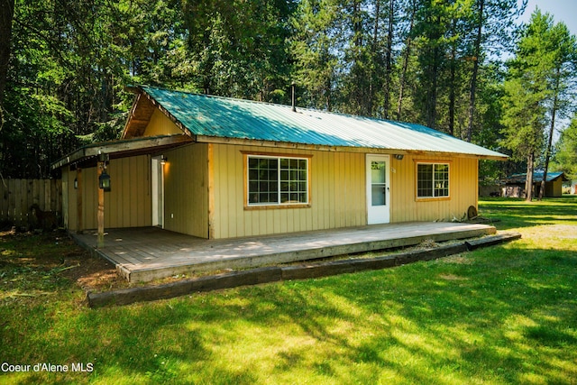 view of front of property featuring metal roof, a front lawn, and a wooden deck