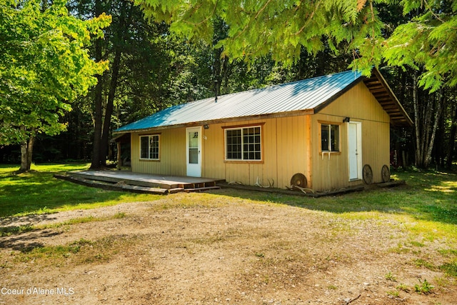 view of front of property featuring metal roof and a front lawn