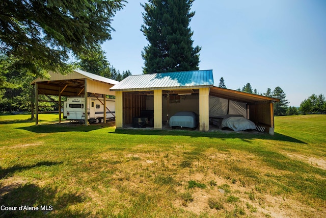 view of pole building with a detached carport and a lawn