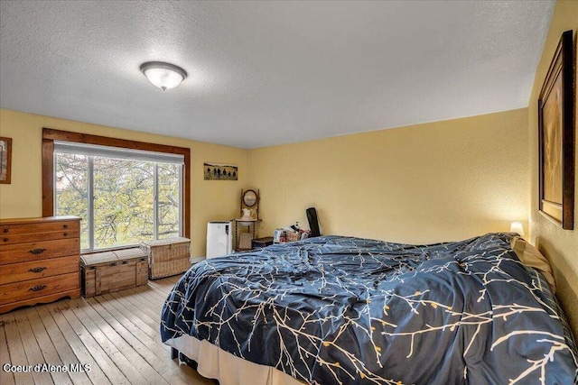 bedroom featuring a textured ceiling and hardwood / wood-style floors