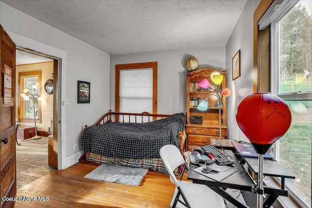 bedroom featuring wood-type flooring and a textured ceiling