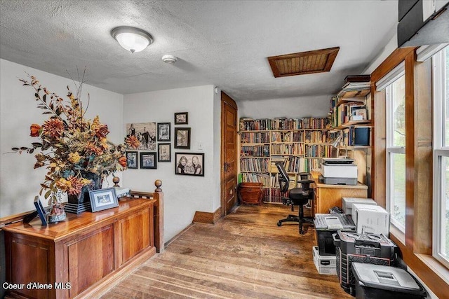 office space with a textured ceiling, wood finished floors, and a wealth of natural light