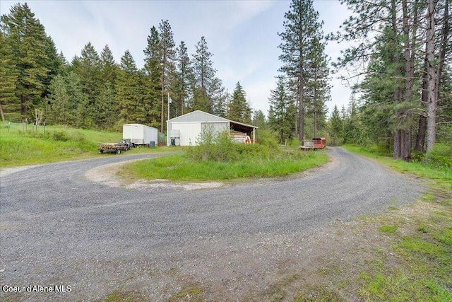 view of road featuring an outbuilding and a forest view