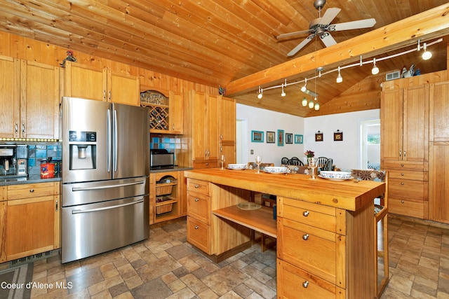 kitchen featuring butcher block counters, wood ceiling, open shelves, stainless steel fridge, and stone tile flooring