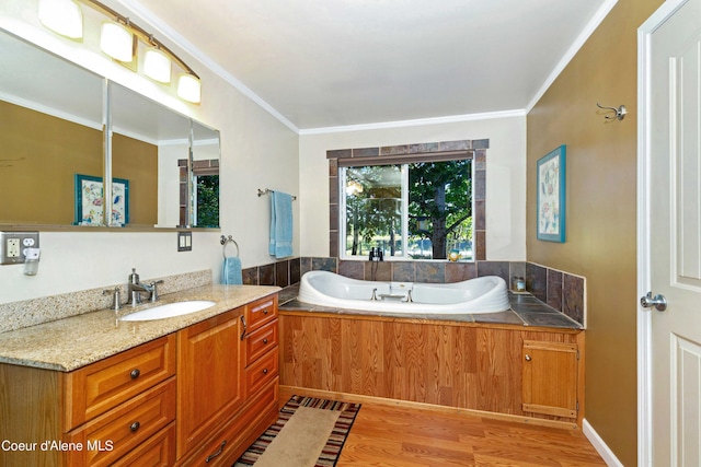 full bathroom with a garden tub, crown molding, vanity, and wood finished floors