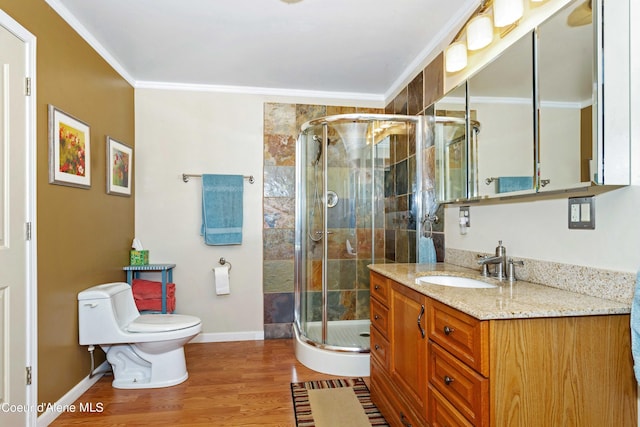 bathroom featuring wood finished floors, a shower stall, toilet, and crown molding