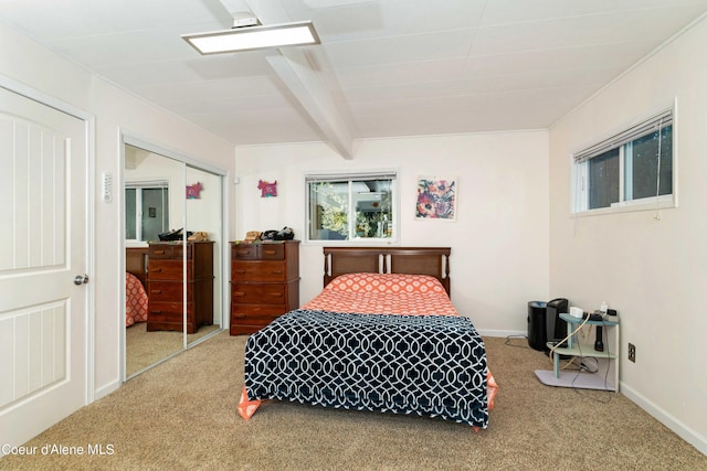 carpeted bedroom featuring a closet, beam ceiling, and baseboards