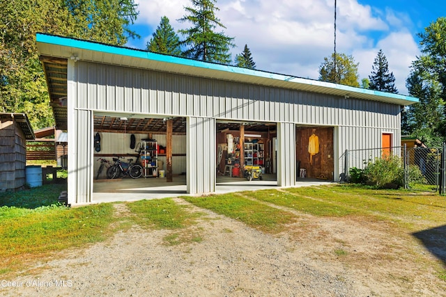 rear view of house featuring a garage, a pole building, and an outdoor structure