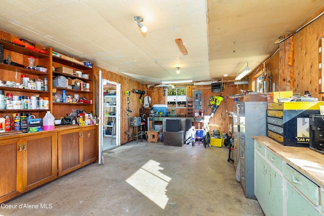 interior space with concrete floors, wood walls, and a workshop area