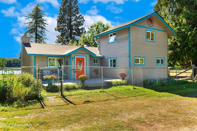 view of front facade featuring a fenced front yard, a gate, a chimney, and a front yard