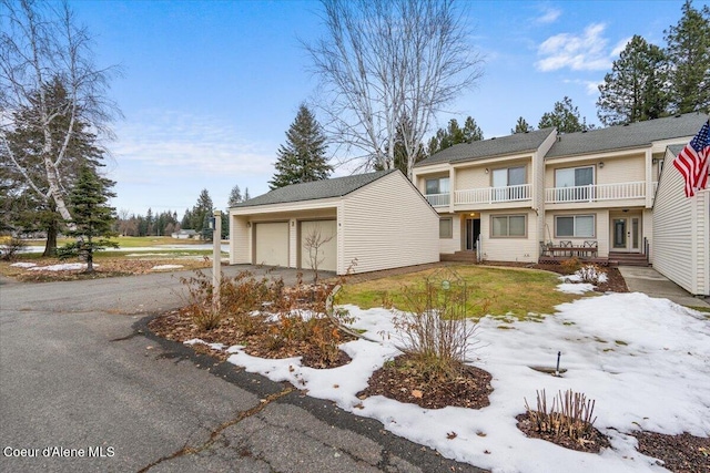 view of front of property featuring a balcony, a garage, and an outdoor structure